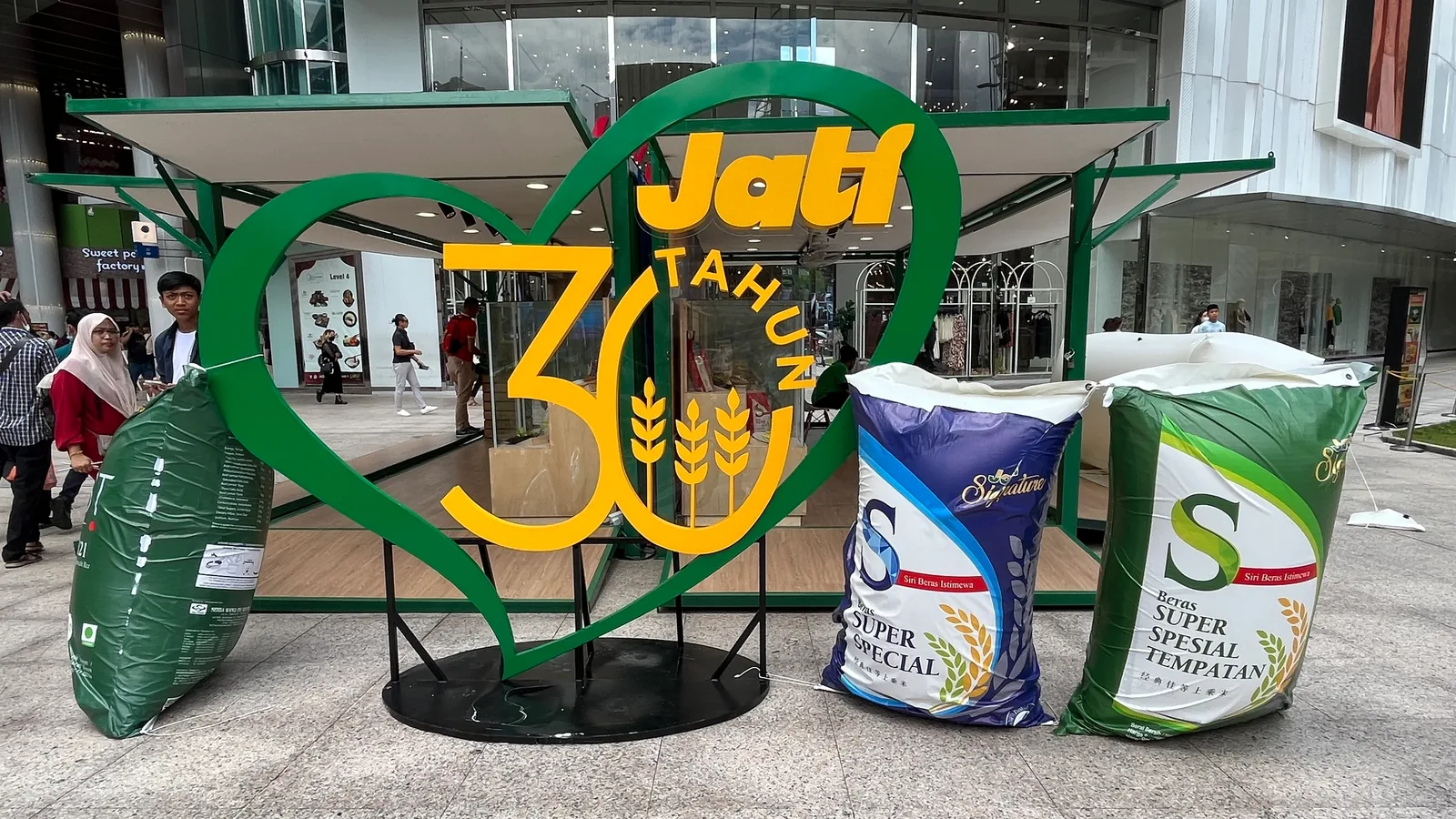Jati rice-pack inflatable replicas beside branded roadshow signage.